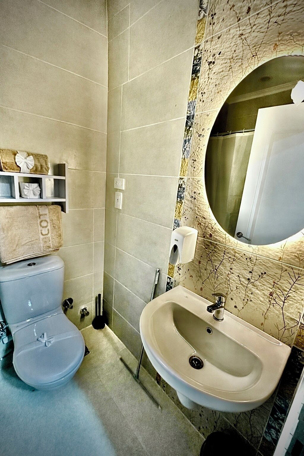 Un baño con inodoro, lavabo y espejo.