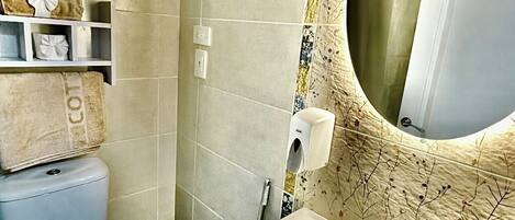 Un baño con inodoro, lavabo y espejo.