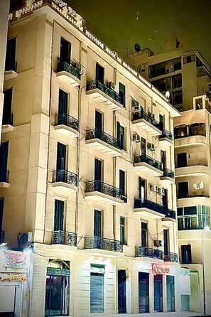 A multi-story building with balconies and a ground-level storefront.