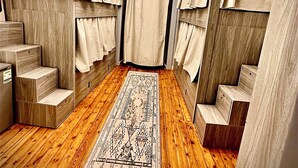 Ein Zimmer mit Holzboden, einem gemusterten Teppich und einer Deckenleuchte.