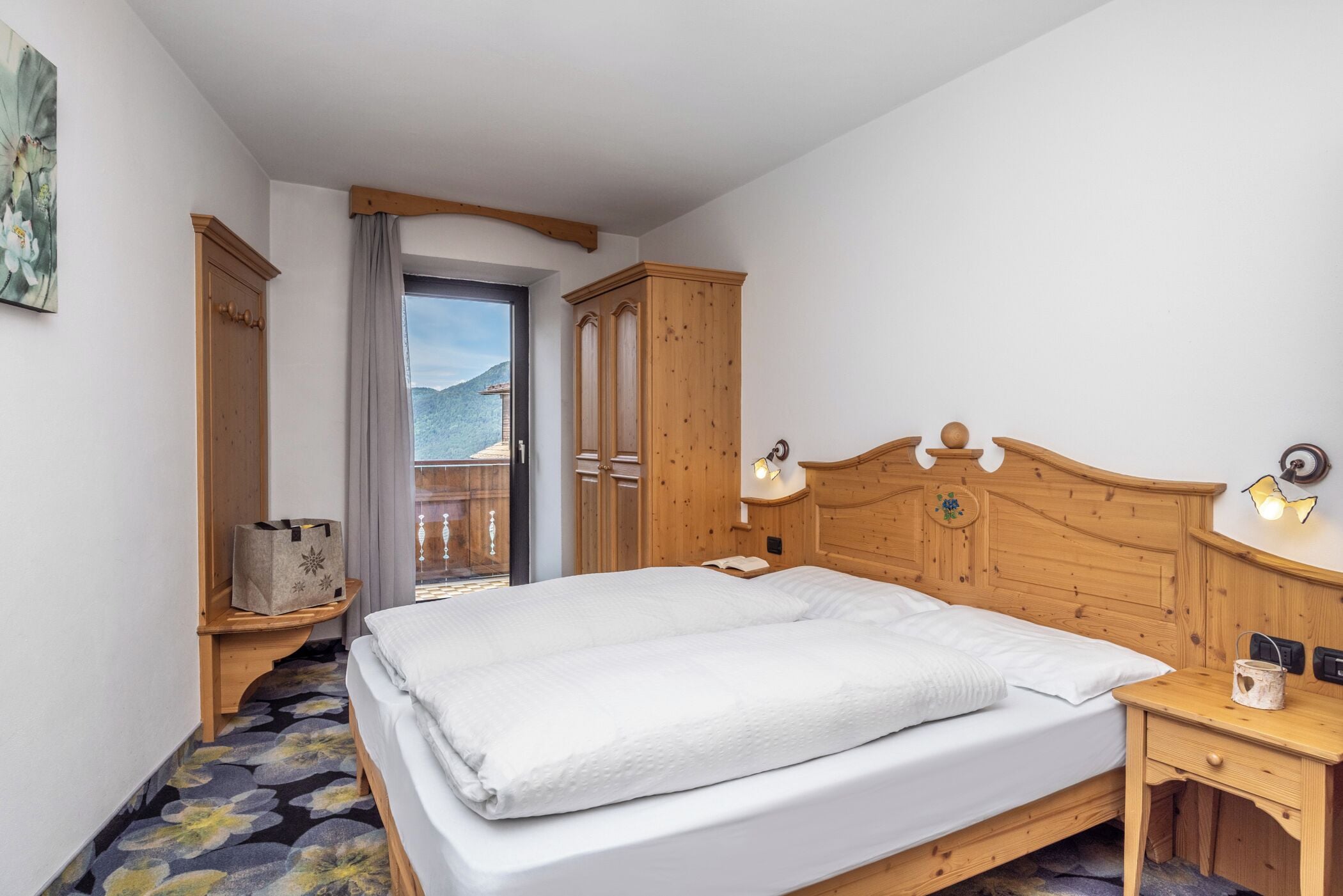 Un dormitorio con cama de madera, una mesita de noche, un armario de madera, una ventana con vistas y un cabecero de madera.