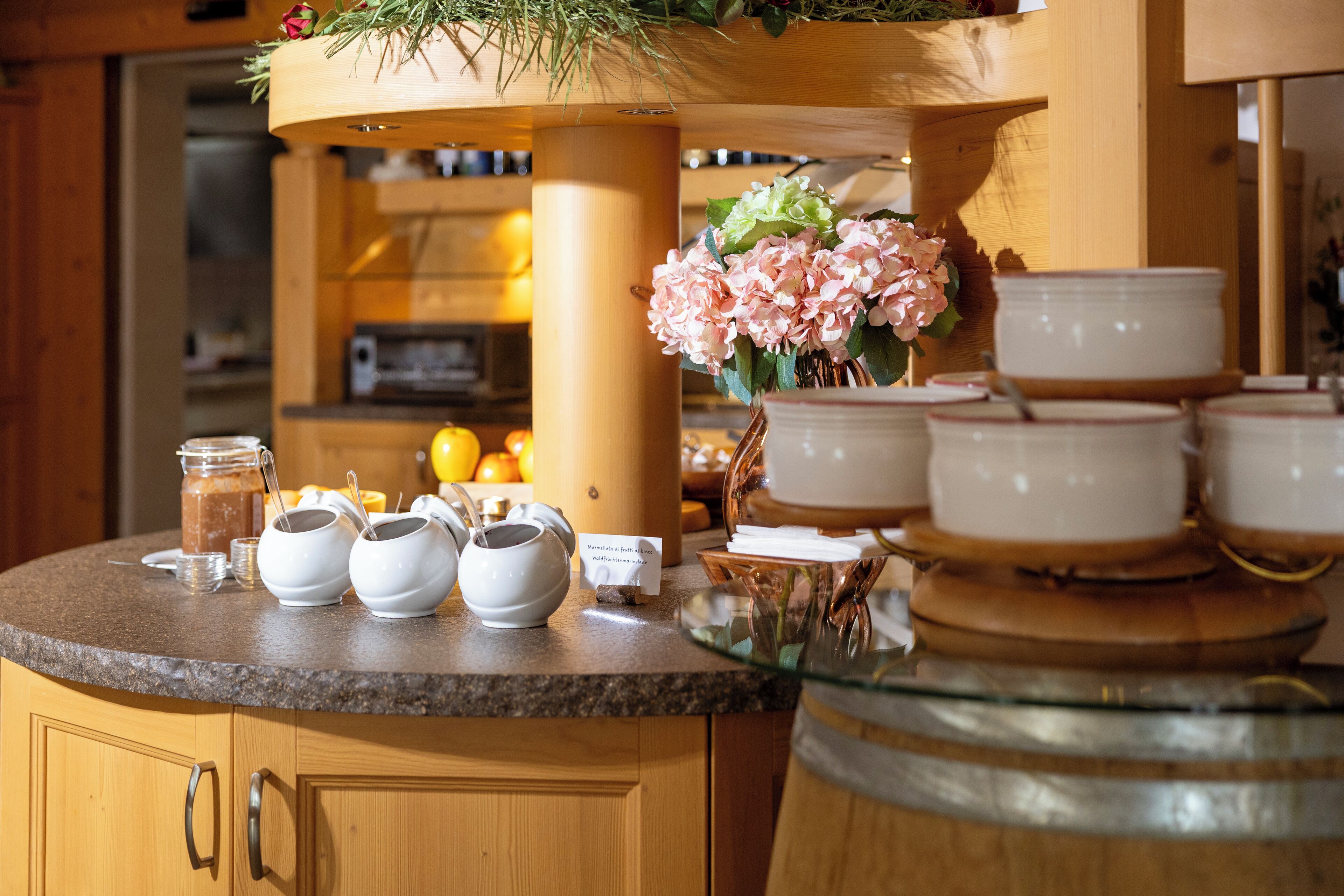Un comptoir de cuisine avec des théières, un vase de fleurs et une machine à café.