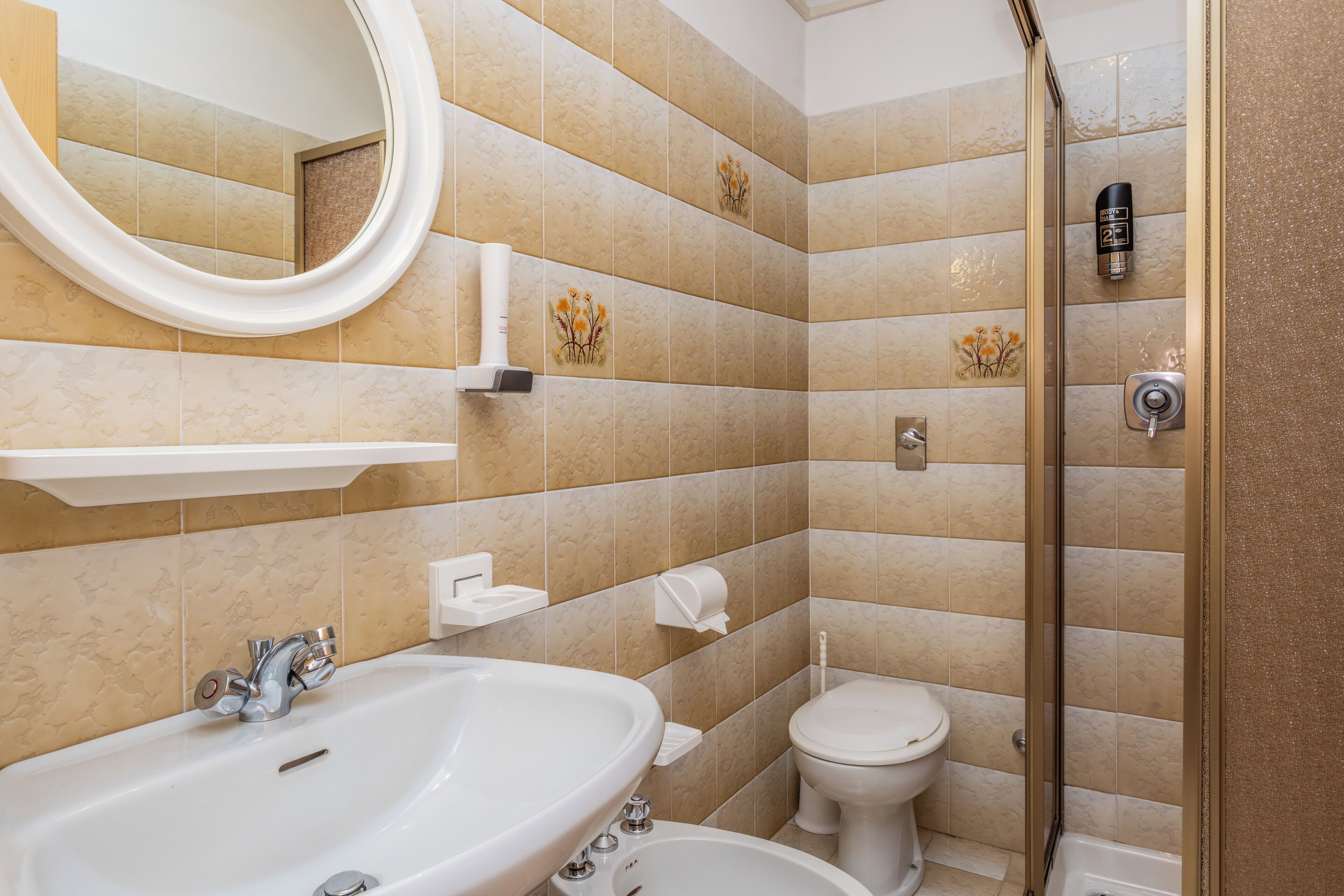 Une salle de bain avec un grand lavabo, des toilettes et un espace douche.