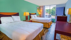 Une chambre d’hôtel avec deux lits, un bureau et une vue sur l’extérieur.