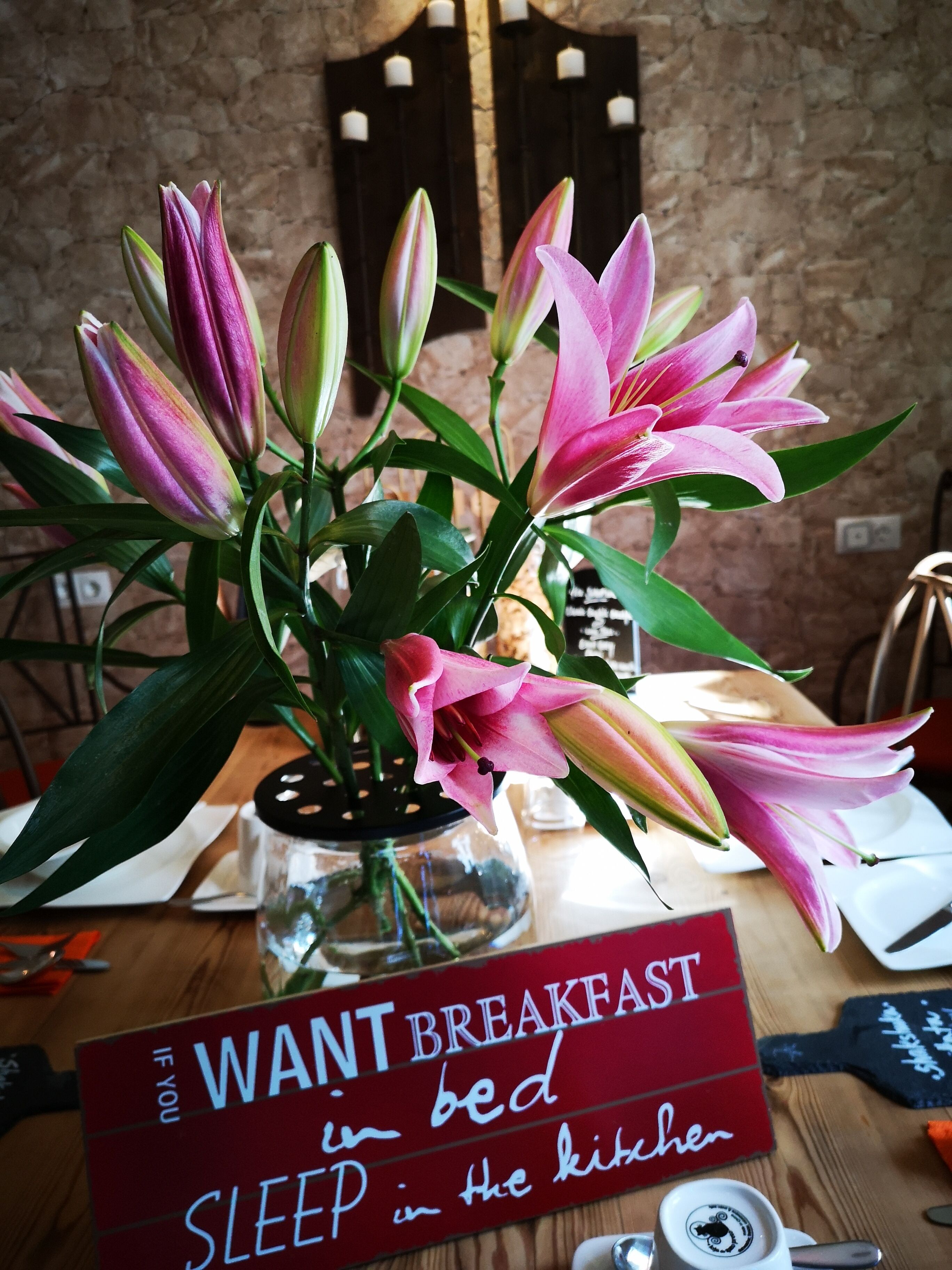 A table with a sign that reads "WANT BREAKFAST in bed SLEEP in the kitchen."
