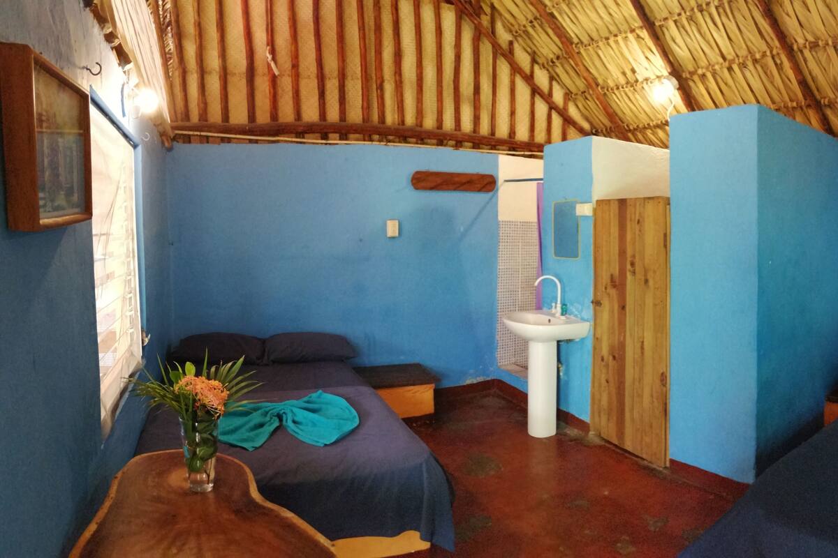 A room with two beds, a sink, and a window.