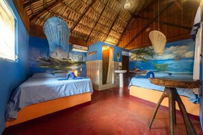Ein Zimmer mit zwei Betten, einem Waschbecken und einer Wandmalerei mit Strandmotiv.