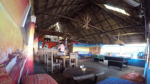 Un ambiente interior rústico con muebles de madera, una mesa de billar y una zona de bar.