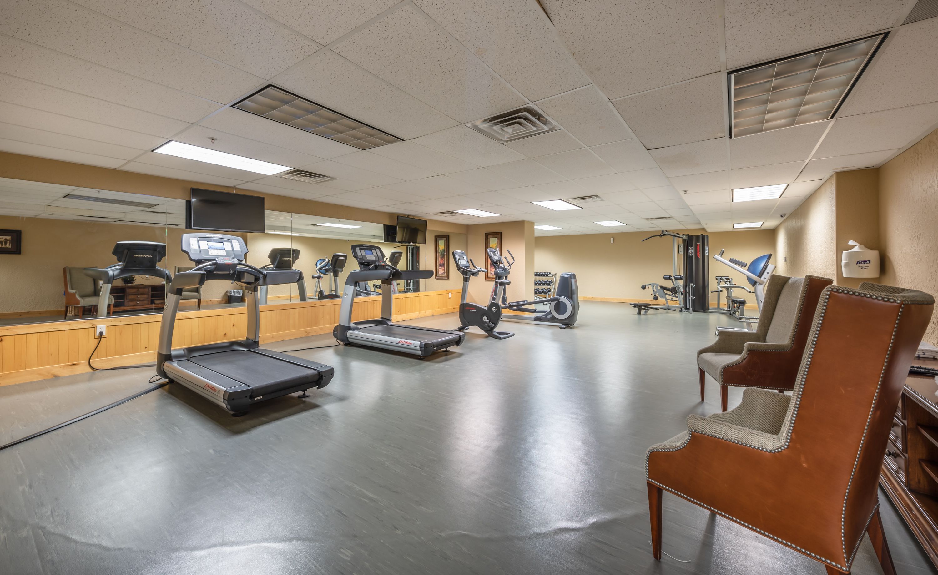 A gym with treadmills, stationary bikes, and weight machines.