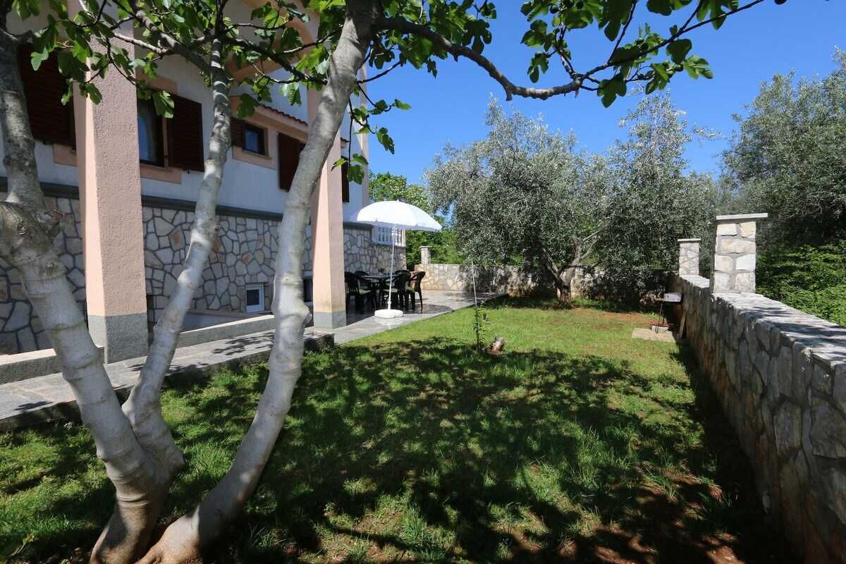 A building with a stone facade, a patio with outdoor furniture, and a stone wall.