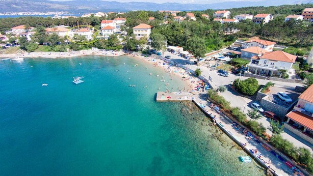 A coastal town with clear waters, a beach, and residential buildings. - Apartment Hodzic nr 3 (Silo - island Krk)