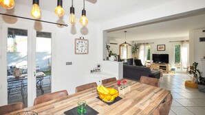 A modern kitchen with a dining area, a living room, and a TV in the background. - Pet friendly home in Baixas (Baixas)