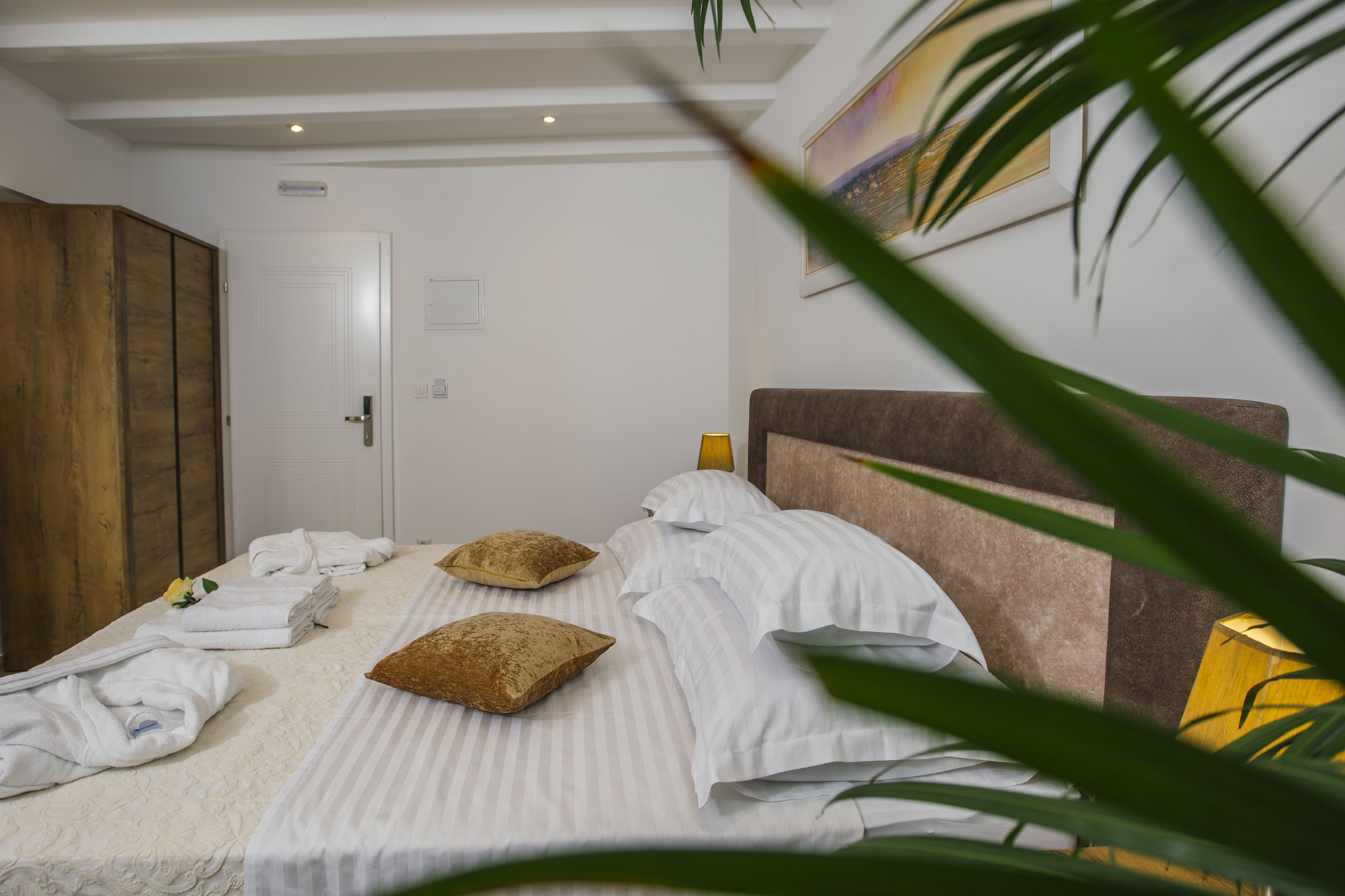 Quarto de hotel com cama, guarda-roupa de madeira e porta.