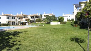 A residential area with multiple two-story houses, a swimming pool, and well-maintained lawns. - Condomínio Vilita, T1-Lt-5,F Pêra-Silves (Pêra)