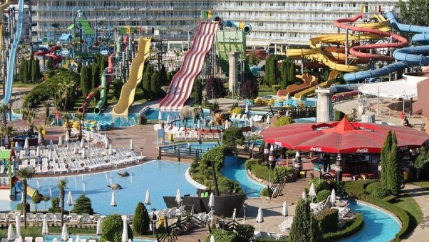 A water park with multiple slides and pools, surrounded by lounge areas and umbrellas. - Charis Cozy Family Apart. at Sun Village  - ONLY 10 mins Walk to the Beach (Bourgas)