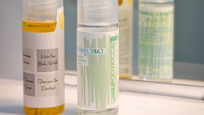 A bathroom shelf with various toiletries including shampoo, body wash, and shower gel.