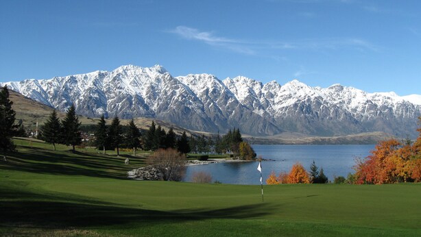 A golf course with a lake and mountains in the background. - Ramada by Wyndham Queenstown Central (Queenstown)
