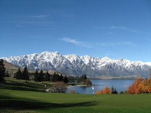 A golf course with a lake and mountains in the background. - Ramada by Wyndham Queenstown Central (Queenstown)