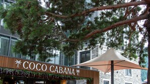 A restaurant named 'Coco Cabana' with outdoor seating and a stone building in the background. - Ramada by Wyndham Queenstown Central (Queenstown)