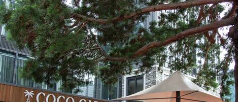 A restaurant named 'Coco Cabana' with outdoor seating and a stone building in the background.