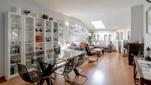 A spacious living area with a glass dining table, comfortable seating, and a large window providing natural light. - Bajamar Nerja II 7 by Casasol (Nerja)