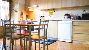 Una cocina con armarios de madera, lavavajillas y una mesa de comedor con sillas.