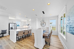 Enjoy meals in this kitchen with a central island, bar stools, and a large island sink, overlooking the ocean.