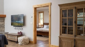 Une pièce comprenant un lit, une armoire en bois, un téléviseur et une cheminée en pierre.
