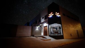 Un hôtel moderne dont les fenêtres offrent une vue sur un ciel étoilé.