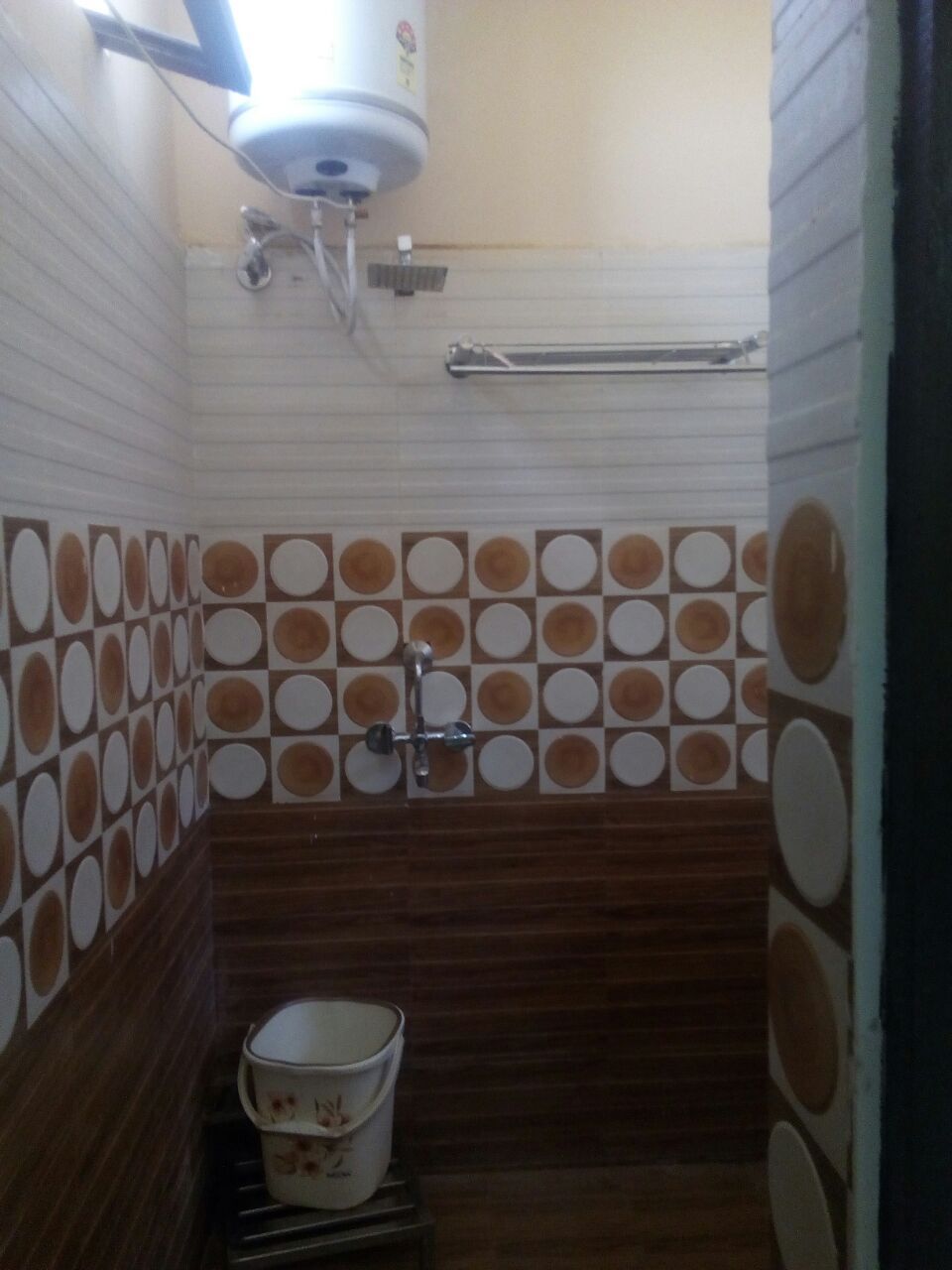 Un baño con inodoro, bidé, secador de manos y un balde.