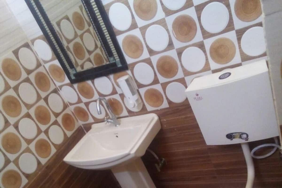 Un baño con lavamanos, inodoro y espejo.