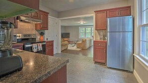 Una cocina moderna con encimeras de granito, electrodomésticos de acero inoxidable y armarios de madera.