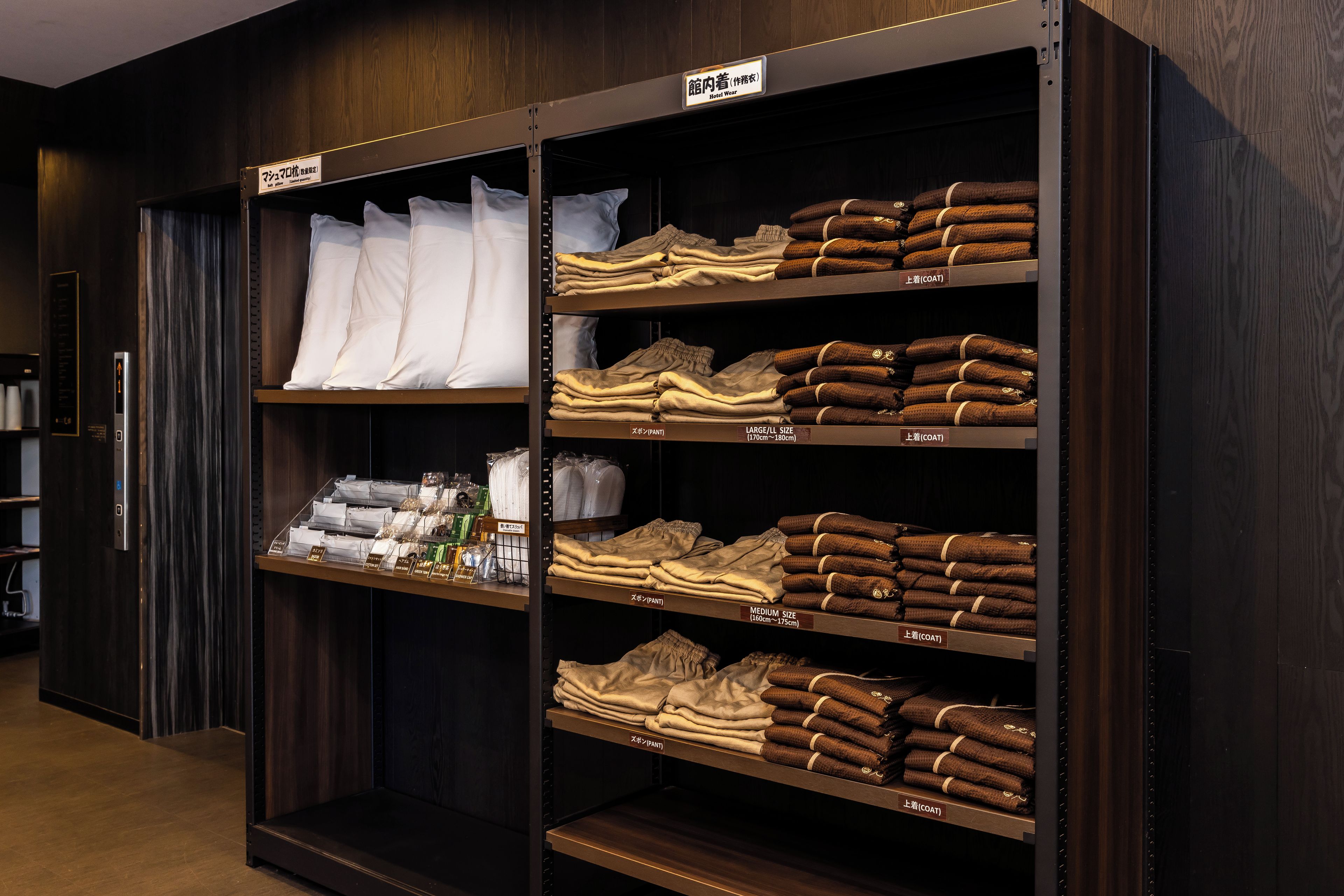 A hotel closet with shelves labeled for different types of hotel wear, including shirts and pants.