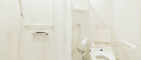 A bathroom with a toilet, a shower, and a towel rack.