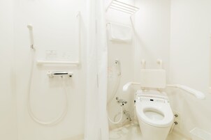 A bathroom with a toilet, a shower, and a towel rack.