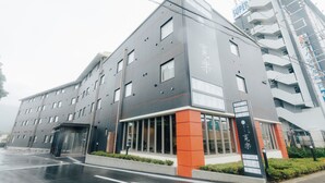 Un hôtel moderne, avec plusieurs étages, de grandes fenêtres et une entrée imposante.