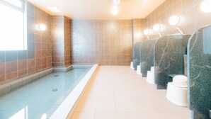 Des toilettes publiques avec plusieurs urinoirs, un sol carrelé et une fenêtre sur le côté gauche.