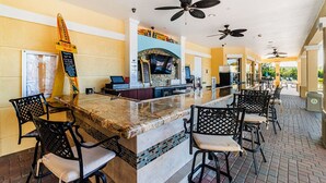 A bar area with a counter, seating, ceiling fans, and a sign. - New Listing! Vista Cay Resort, 7mi to Disney & 3mi to Universal - IT735 (Orlando)