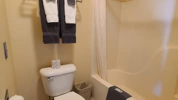 A bathroom with a toilet, a bathtub, and a shower curtain.