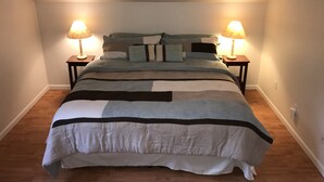 A neatly made bed with striped bedding and two bedside lamps. - Misty Lake Carriage House (Wasilla)