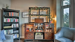 Un accogliente soggiorno con una libreria, un mobile in legno con vetrate e un divano decorato.