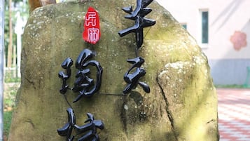 Una piedra con caracteres chinos y un letrero rojo.