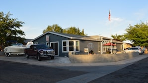 Un bâtiment avec un garage, un drapeau et une remorque pour bateau.