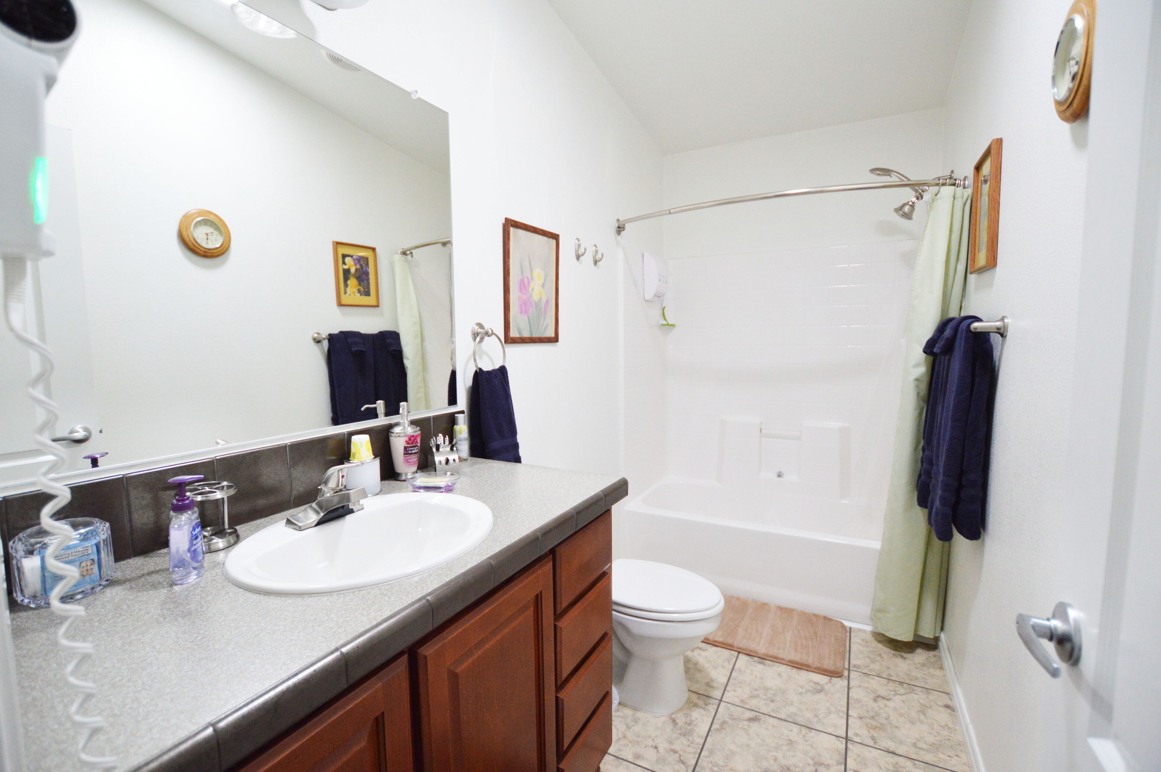 A bathroom with a sink, mirror, toilet, and bathtub.