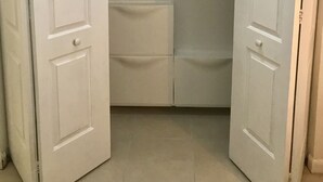 Un dressing avec deux portes, une tringle et une étagère.