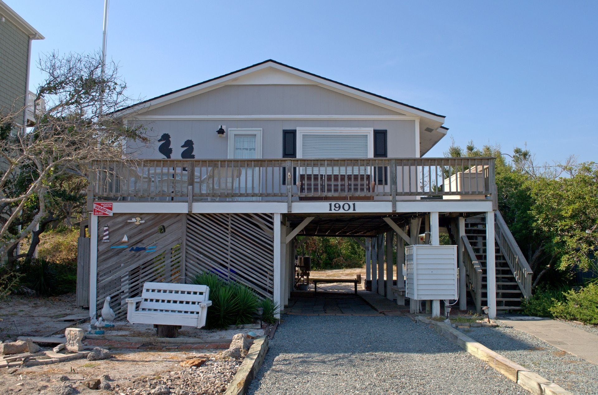 A two-story building with a balcony, a garage door, and a number '1901' on the front.
