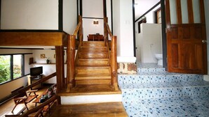 A wooden staircase leading to a bathroom with a tiled floor.
