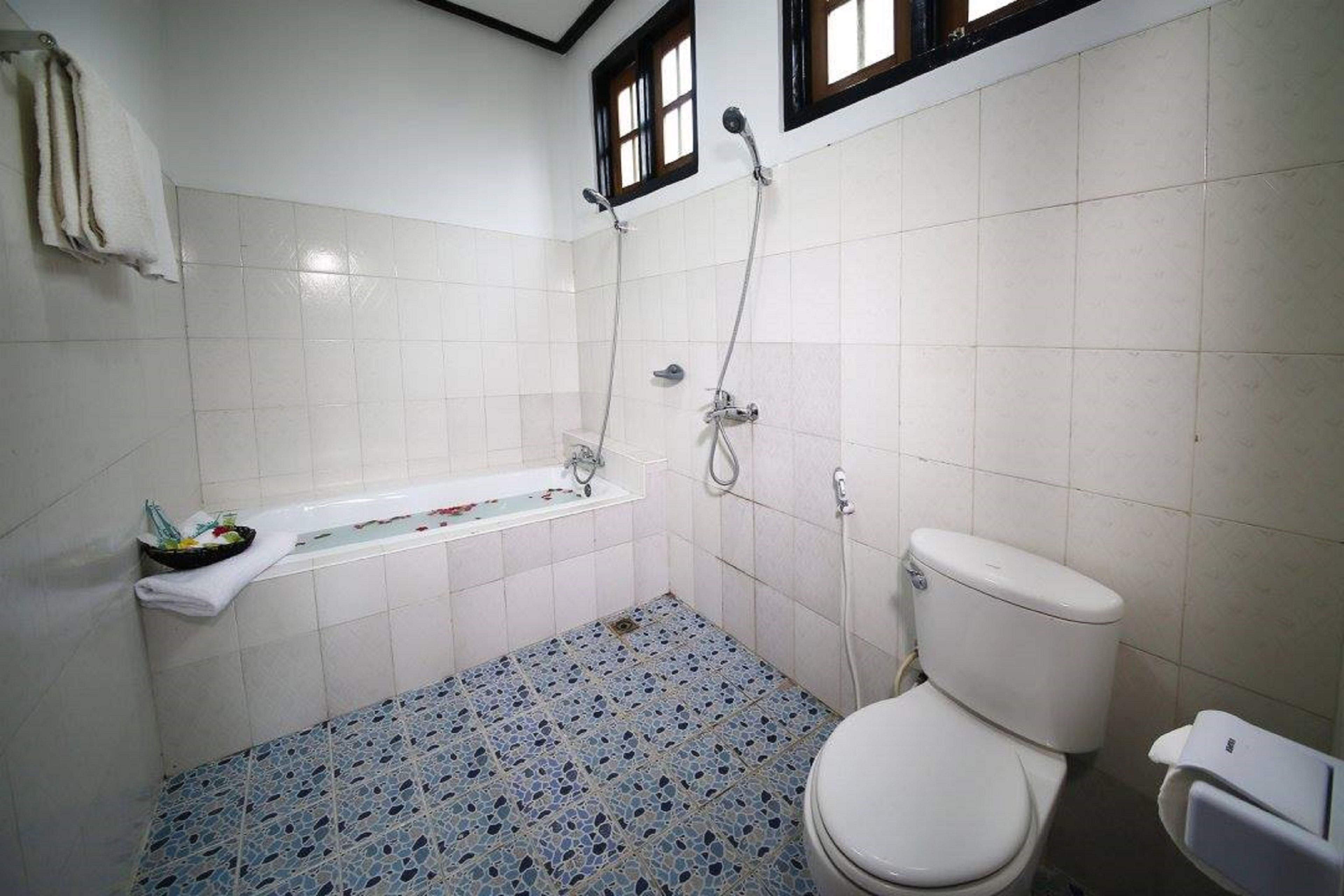 A bathroom with a white toilet, a bathtub, and a shower.
