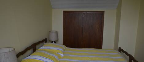 Ein Schlafzimmer mit einem Bett, einem Holzschrank und einer Nachttischlampe.