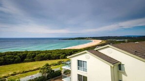 Vista costera con playa, una casa con balcón y un cartel de 'No Parking'.
